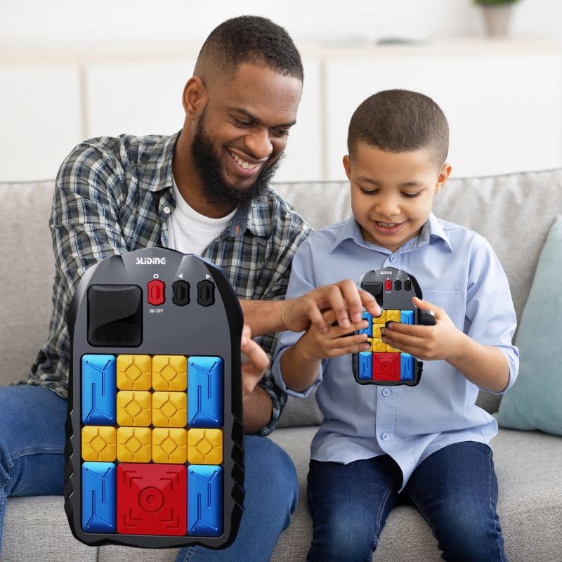 un père joue avec son fils en duel avec leur jeu de logique casse tête électronique