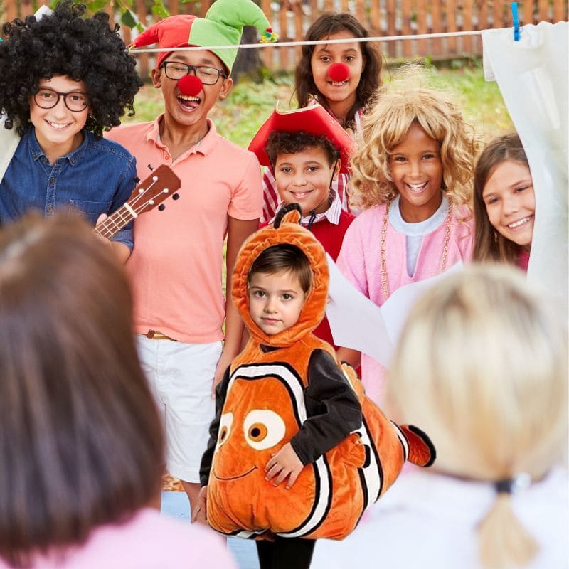 des enfants sont déguiser et s'amusent à faire du théâtre dans la cour la vedette porte un éguisement de poisson