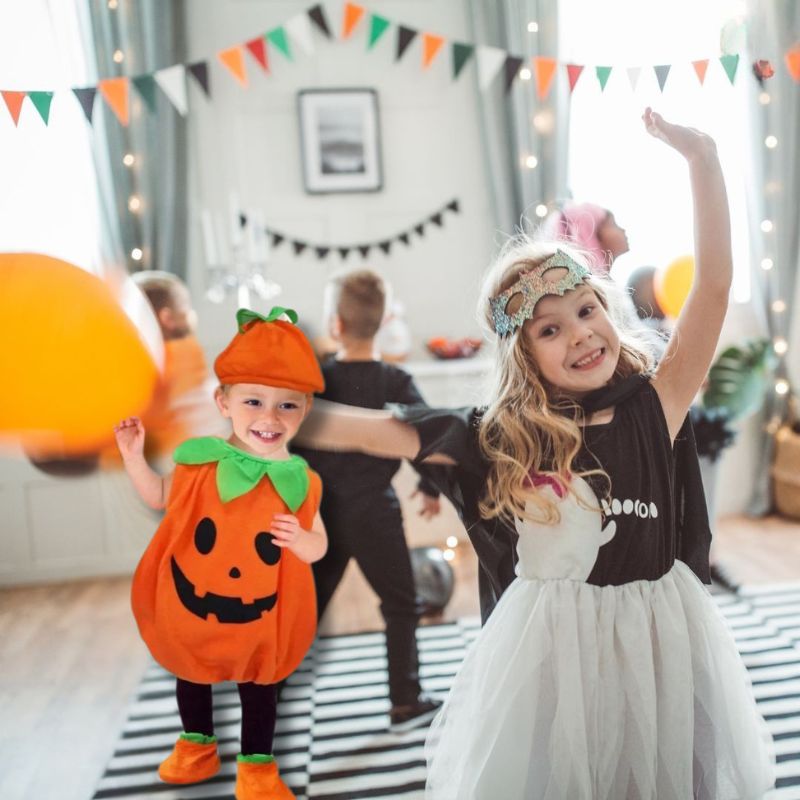 des enfants dansent dans la fête déguisées avec un garçon porte un déguisement enfant citrouille original et confortable.