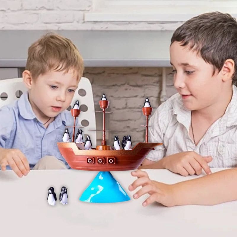 2 garçons rigolent en jouant au jeu de société 3 ans du bateau pirates et du naufrage des pingouins