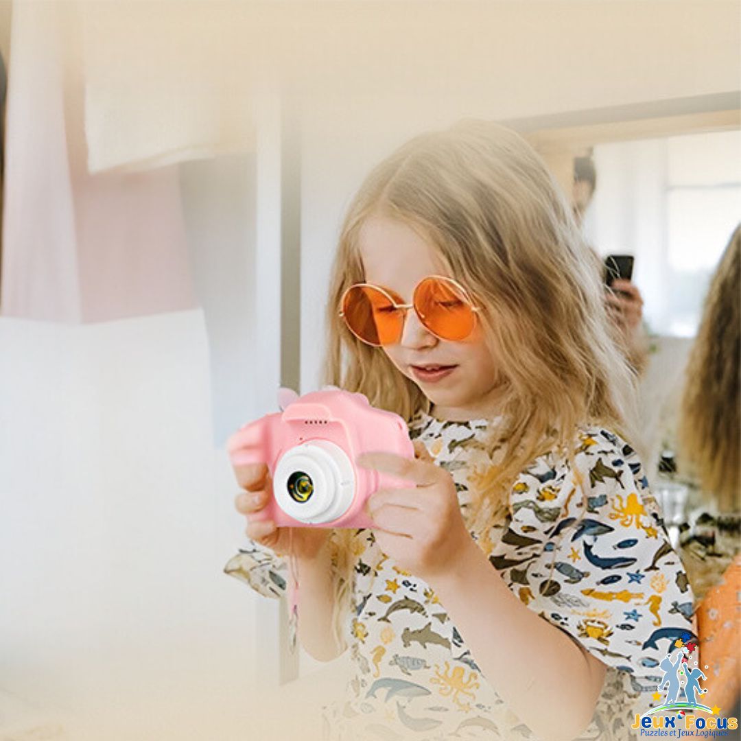 appareil photo enfant dans les mains d'une fillette qui observe ses vidéos enregistré si facilement  rose