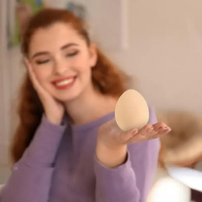 une femme tient sa balle anti stress en forme d'eu beige dans sa main pour e détendre
