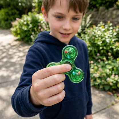 un garçon montre son hand spinner en plastique vert