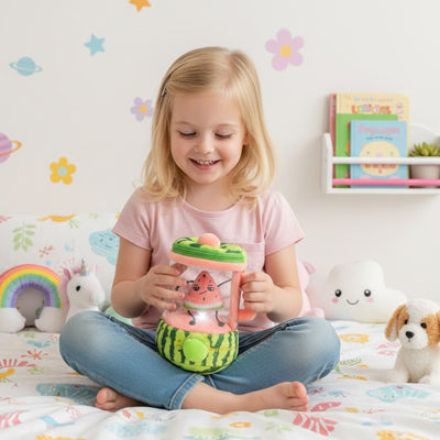 une petite fille tient sa peluche interactive jouet de cuisine blender pour smoothie's au melon et pastèque