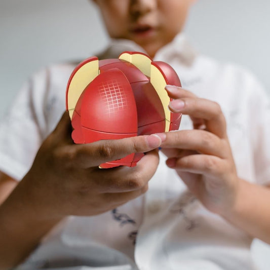 un enfant joue à faire son Puzzle 3d en forme de grosse pomme roughe rubik fruit 