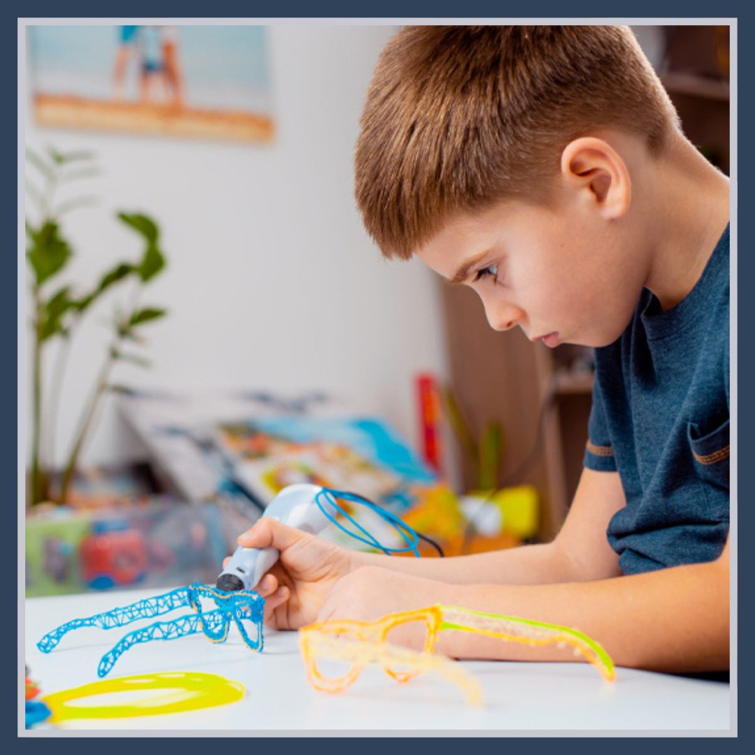 un garçon est très concentré à faire sa création avec son stylo 3D enfant