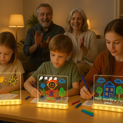 3 petits enfants ont reçun un tableau lumineux à dessin de leur grand parents et ont beaucoup de plaisir