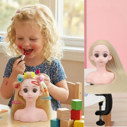 une fillette de 3ans se maquille de rouge à lèvres en jouant avec sa tête à coiffer jouet aux cheveux blonds, longs et lisses