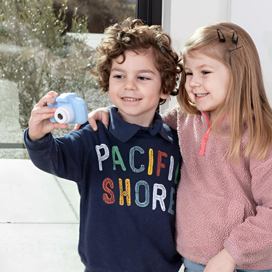 le frère et la soeur regarde leur vidéo sur l'appareil photo enfant cadeau de Noël