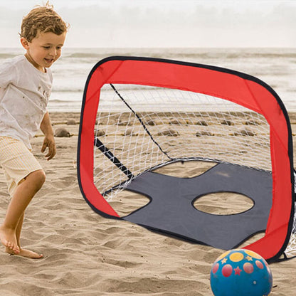 un garçon de 4 ans joue au foot sur la plage avec son but de foot portable dans le sac de plage de maman