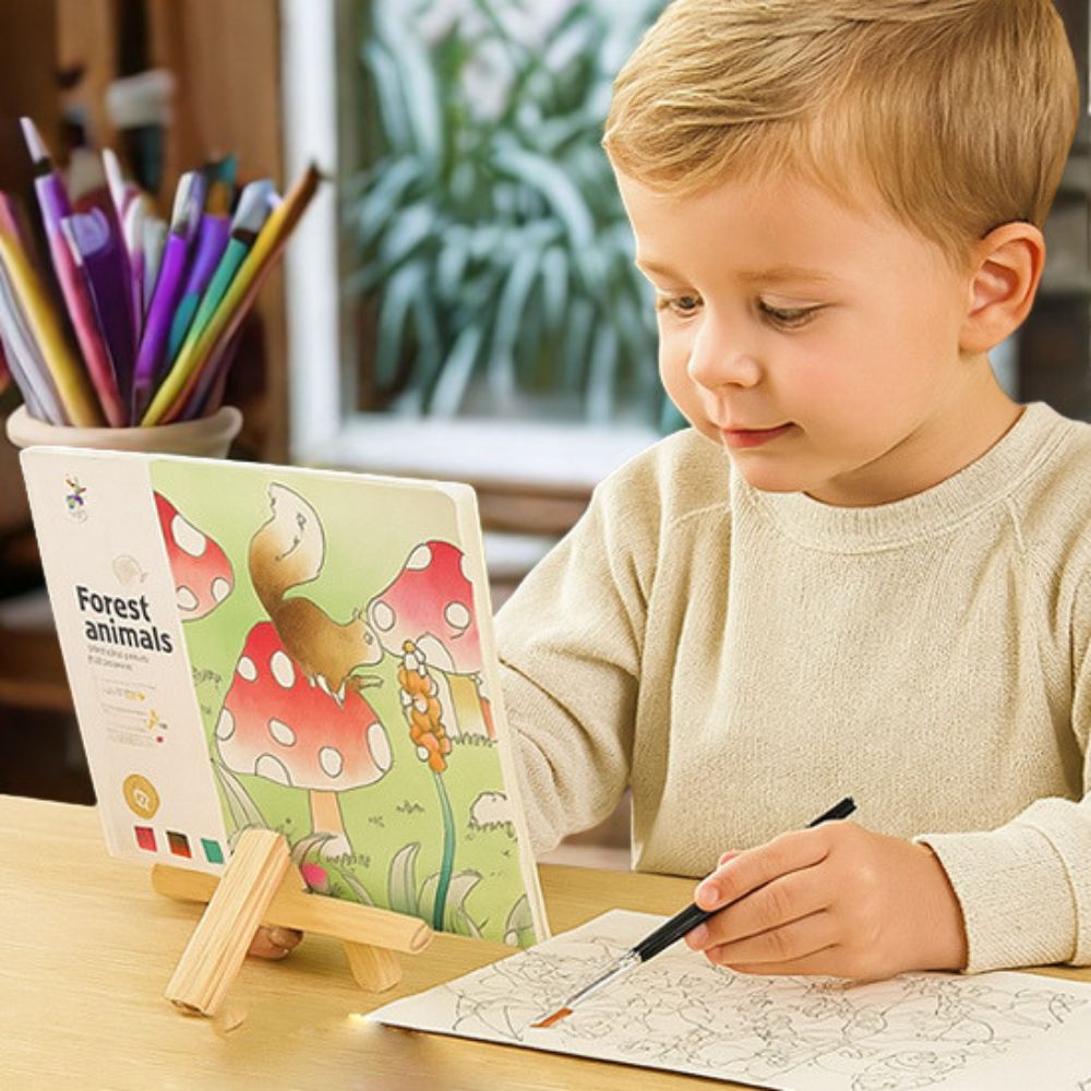 un garçon concentré à peindre son aquarelle dans son cahier de dessin
