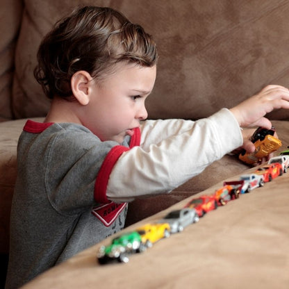 un bambin de 3 ans joue avec ses 24 oitures jouets de son nouveau calendrier de l'avent enfant 2024