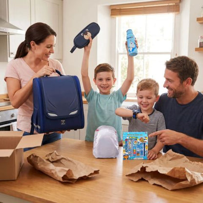 une famille heureuse de déballer le cartable enfant avec tyous ses 5 cadeau offerts gratuitement