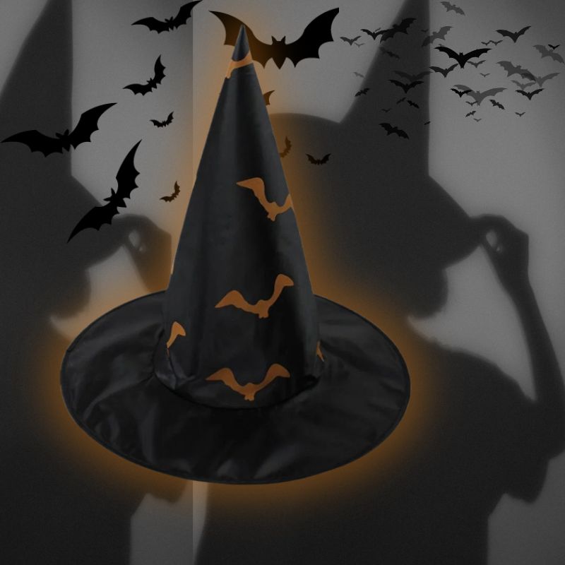 une ombre de sorcière grise regard un chapeau de sorcière noir avec des design de chauve souris oranges