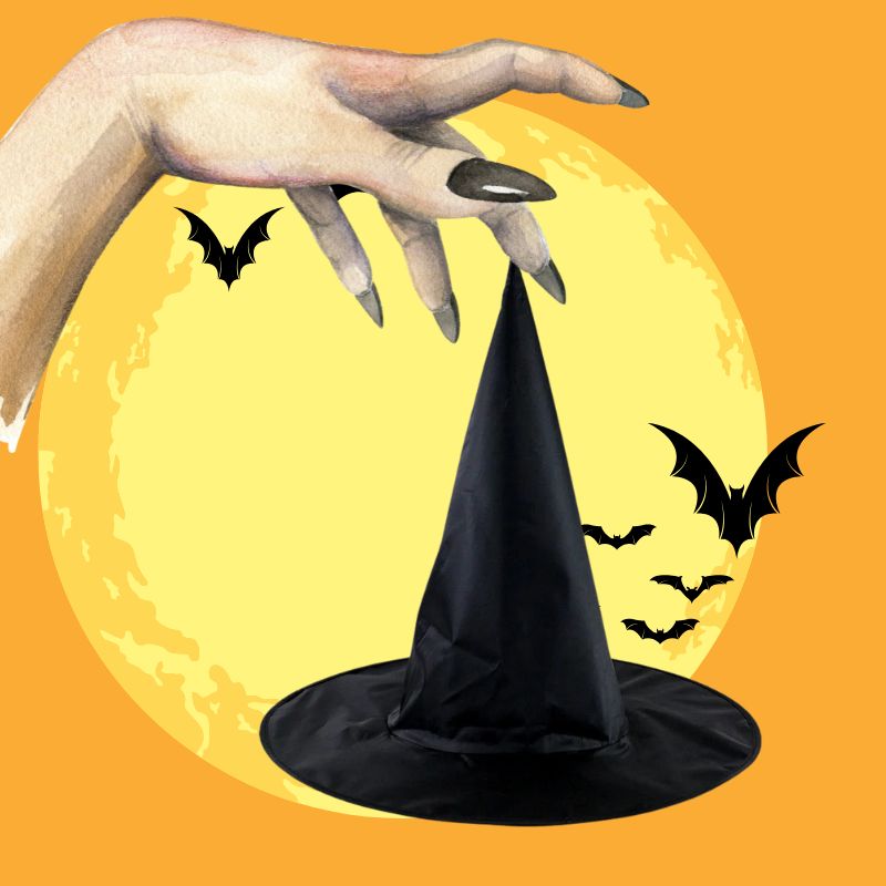 une main de sorcière tient un chapeau de sorcière noir pointu dans les mains