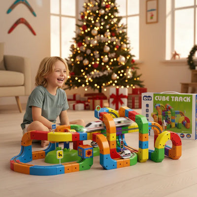 un garçon heureux de son cadeau de Noèl le circuit de voiture et jeu de construction STEM'