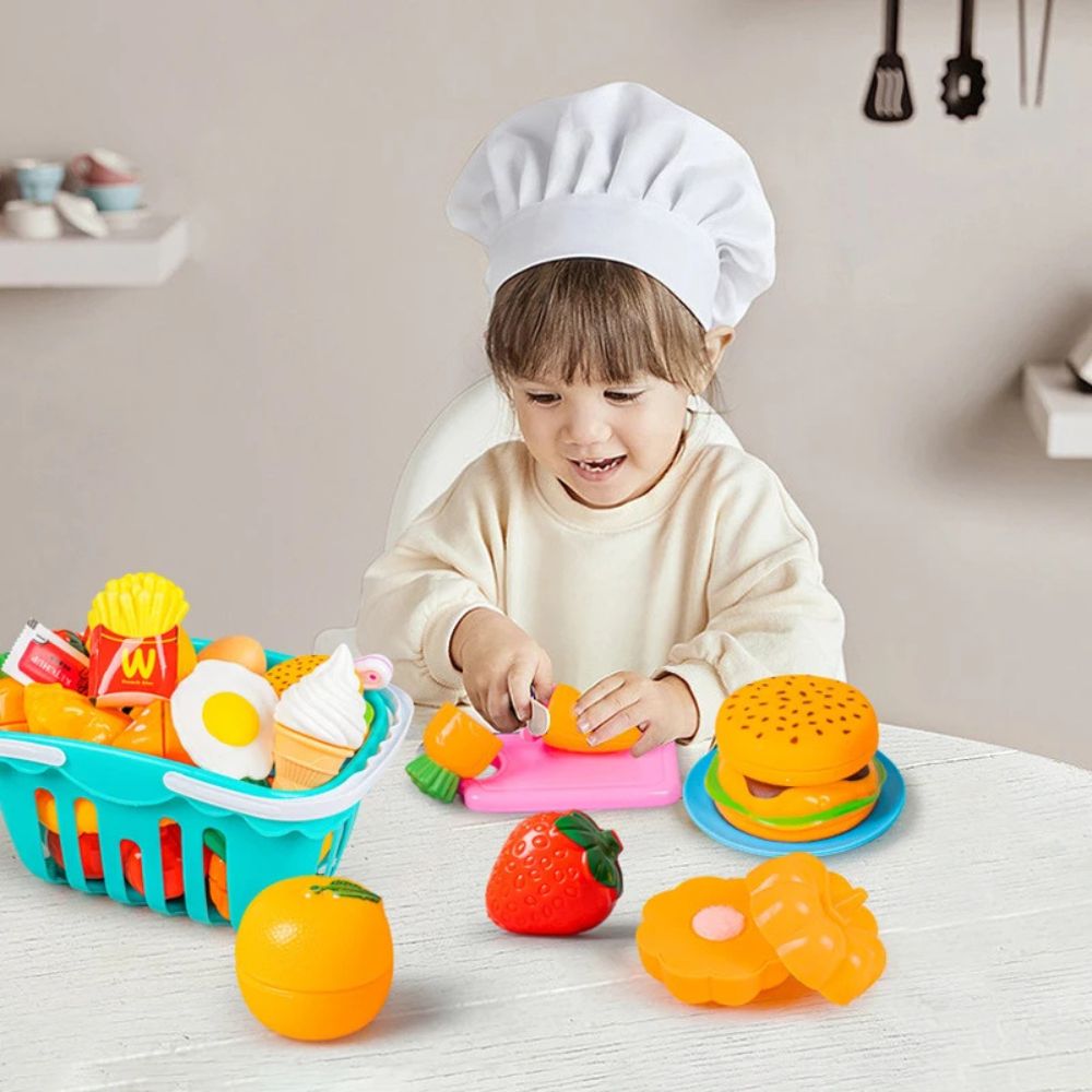 une fillette dans sa dinette découpe des légumes en plastique comme un vrai chef cuisto