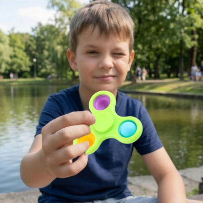 un garçon se détend avec son hand spinner en caoutchou et bulles de Pop It