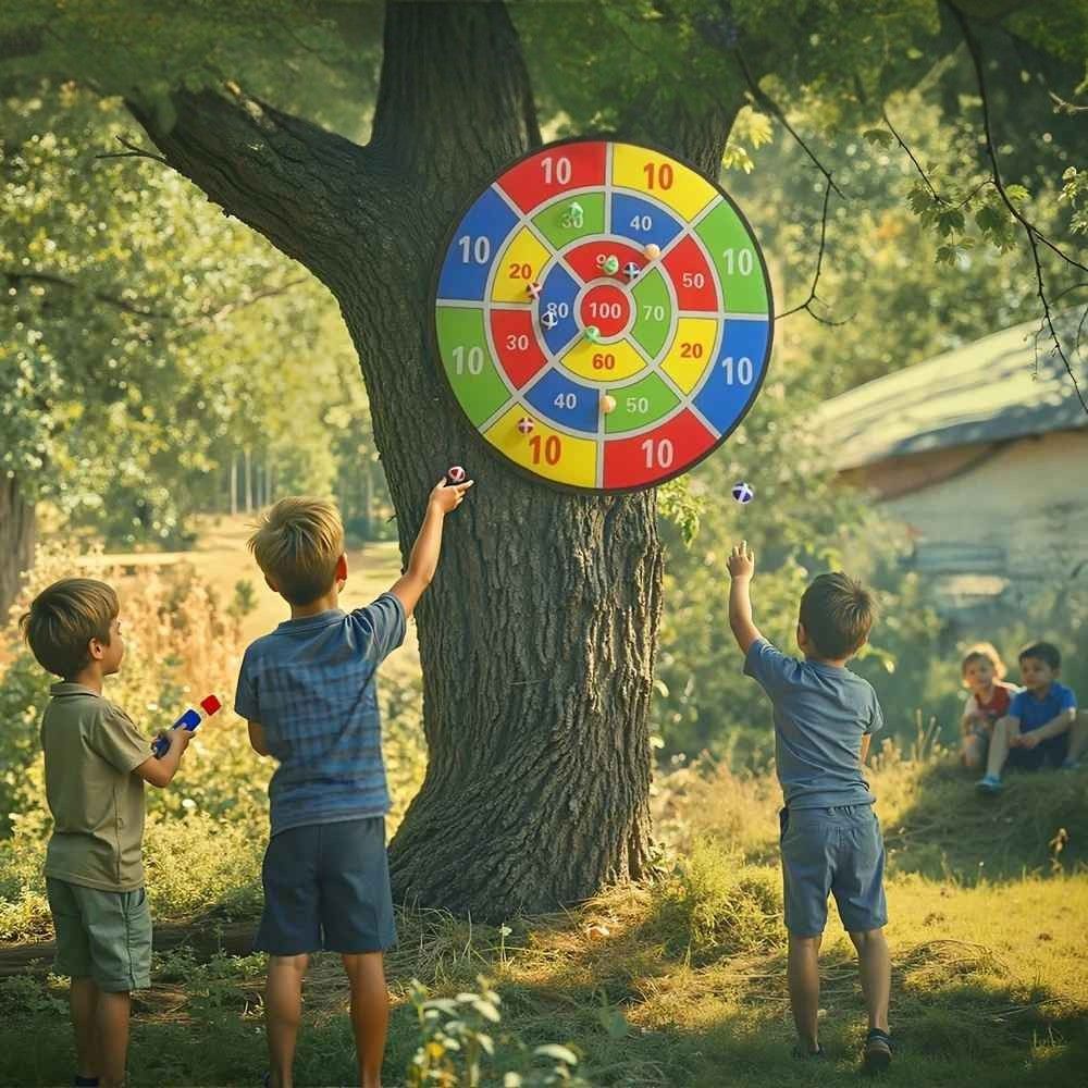 les enfants jouent avec le jeu de fléchettes avec la cible acccrocher à un arbre