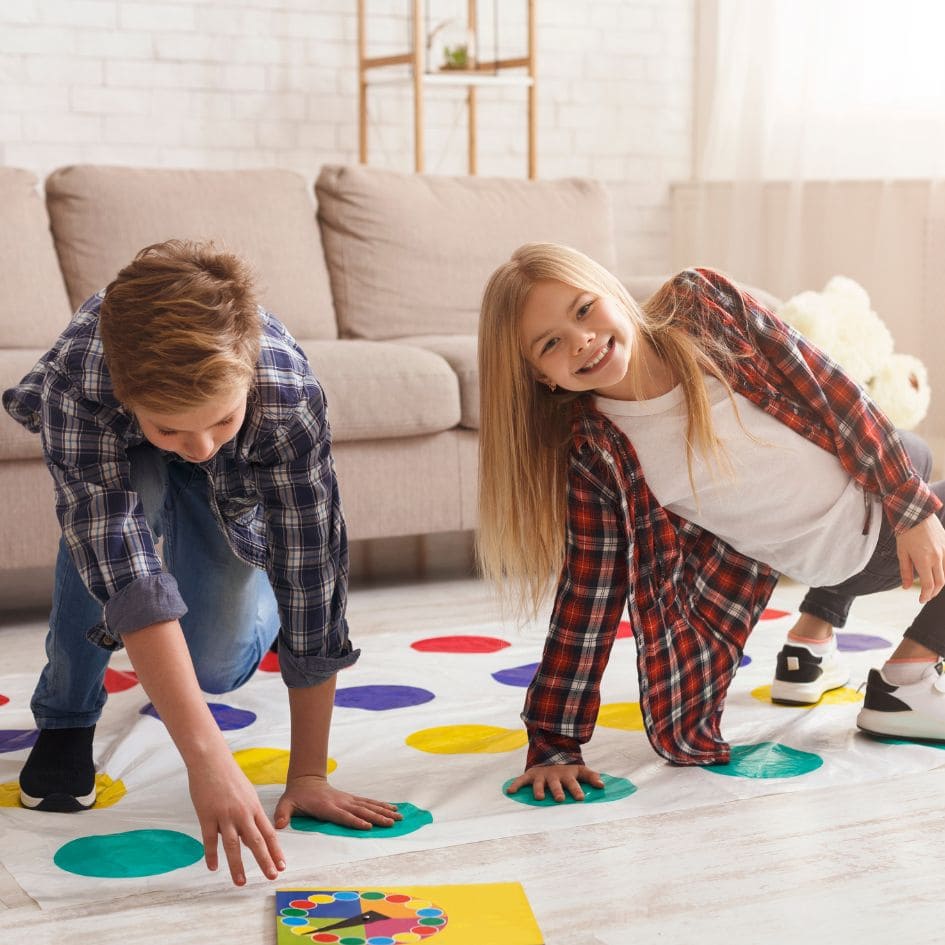 2 enfants ouent au jeu de société twister bien solide dans leur posture