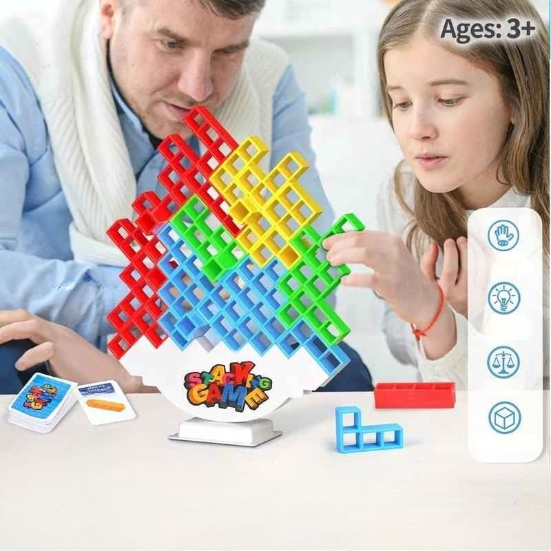 un père et sa fille adolescente jouent au jeu de société enfant  blocs Balance avec concentration et dextérité