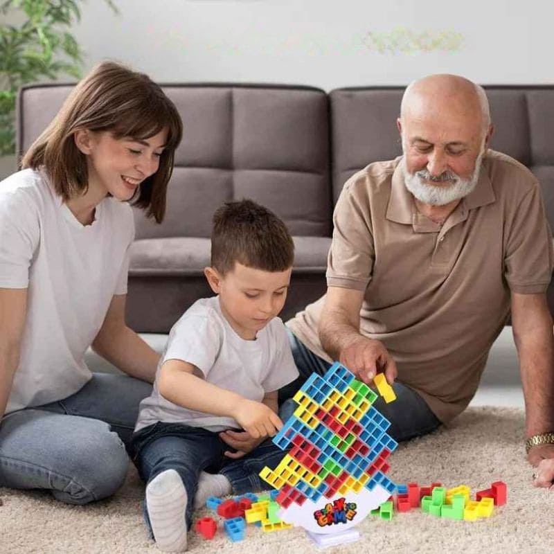 Enfant concentré jouant à un jeu de société enfantavec des blocs colorés en équilibre 