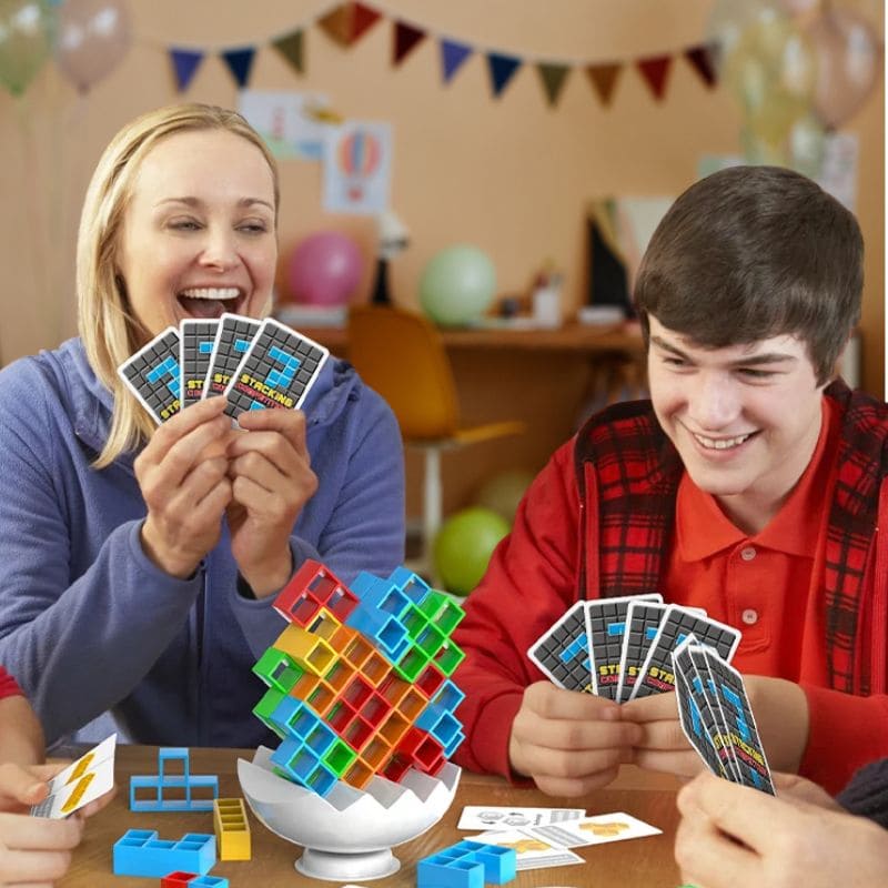 une famille est réunie autour de la table pour jouer au jeu de société enfant que le plus jeune a reçu en cadeau d'anniversaire pour ses 9ans