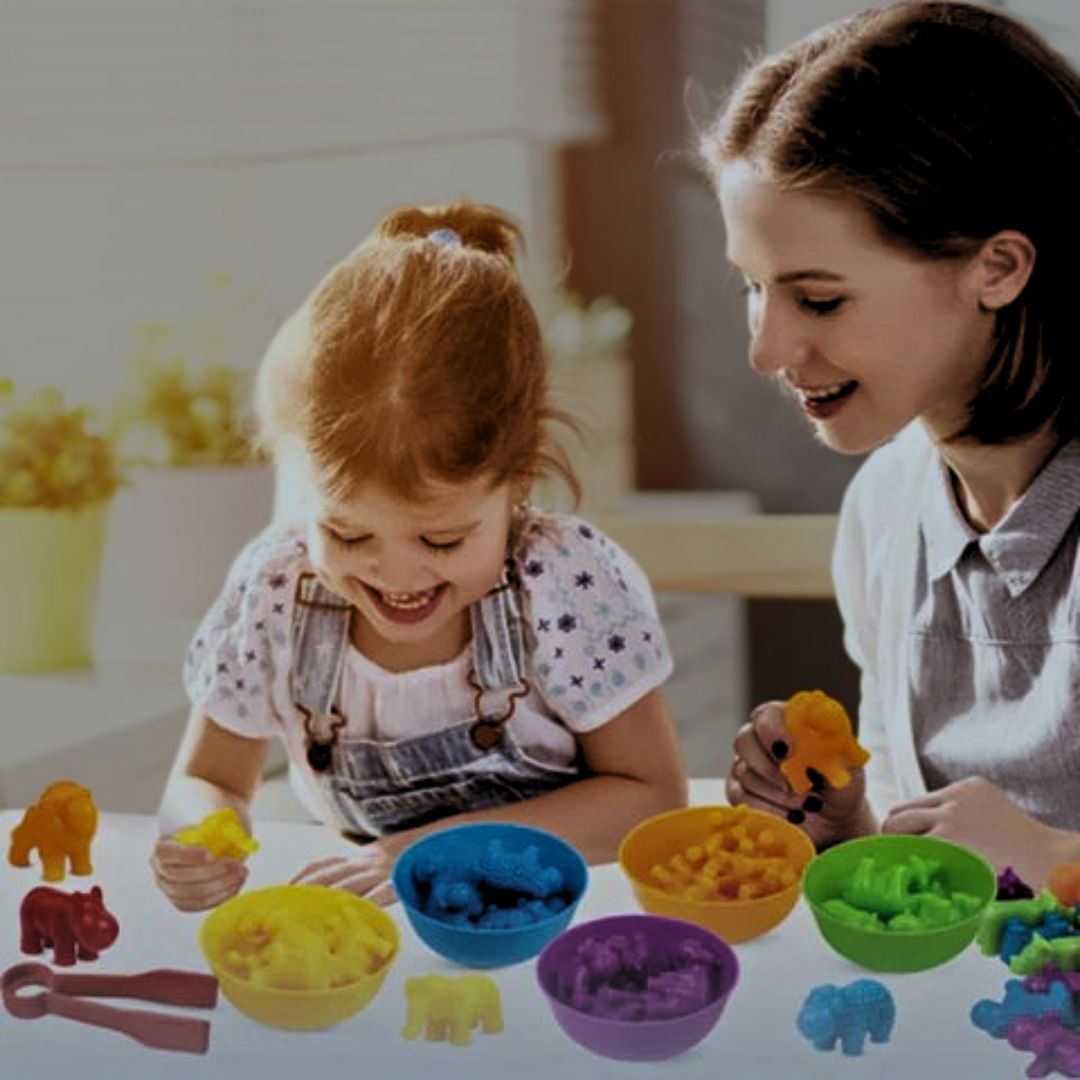 une mère joue avec sa fille avec le jeu montessori aux couleurs de l'arc-en-ciel et pièces en petits animaux