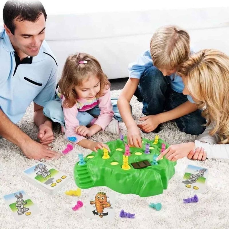une famille de 4 joue à un jeu de société pour enfant de 3 ans installé au sol dans leur salon passe un beau moment en famille