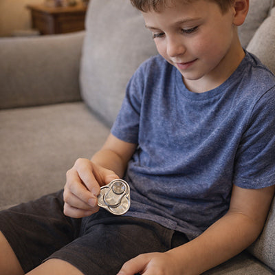 un enfant se recentre motivement avec son jouet anti stress en métal de luxe