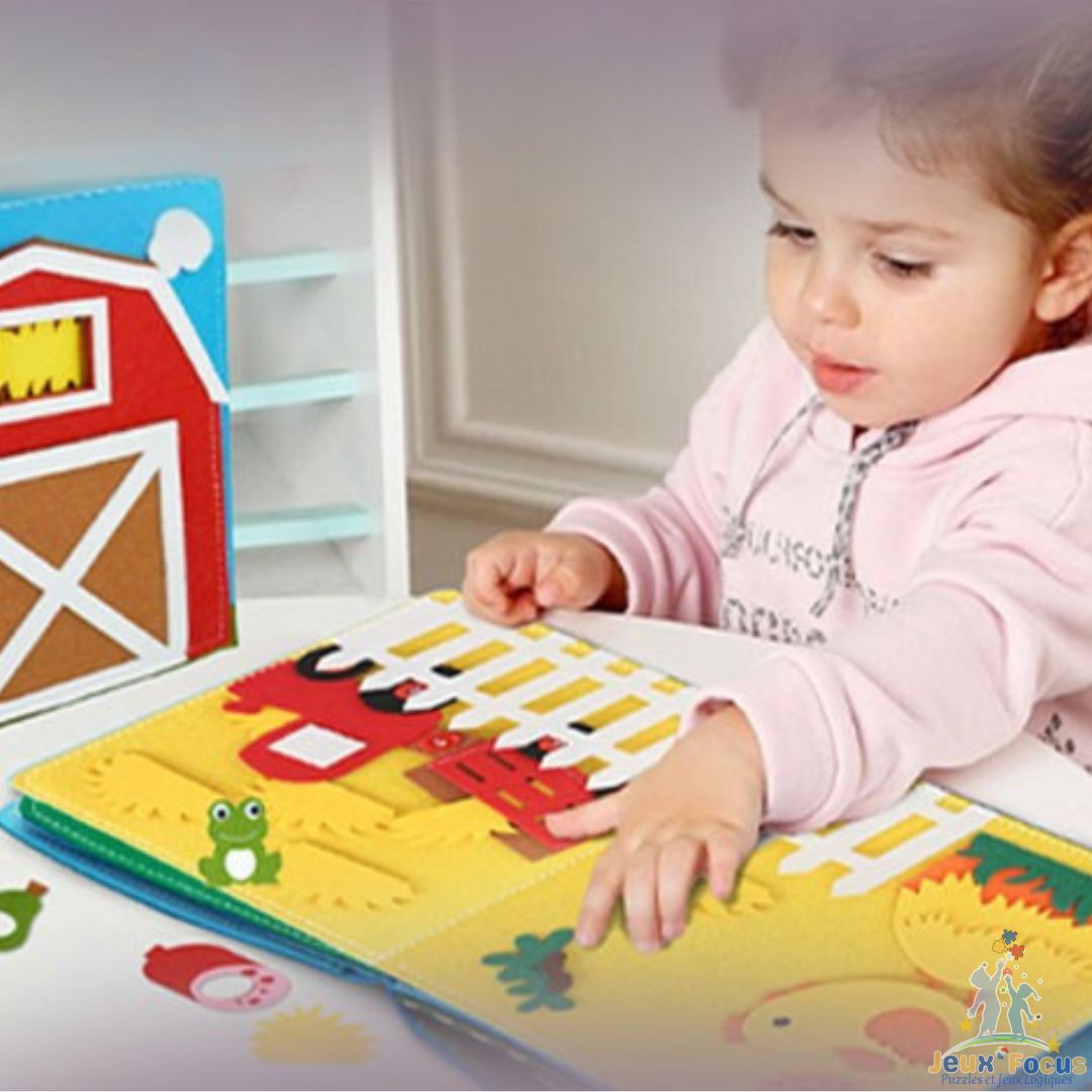 une fillette de 3 ans passionné par son livre enfant 3 ans Mamie-Book à la ferme interactif de Montessori
