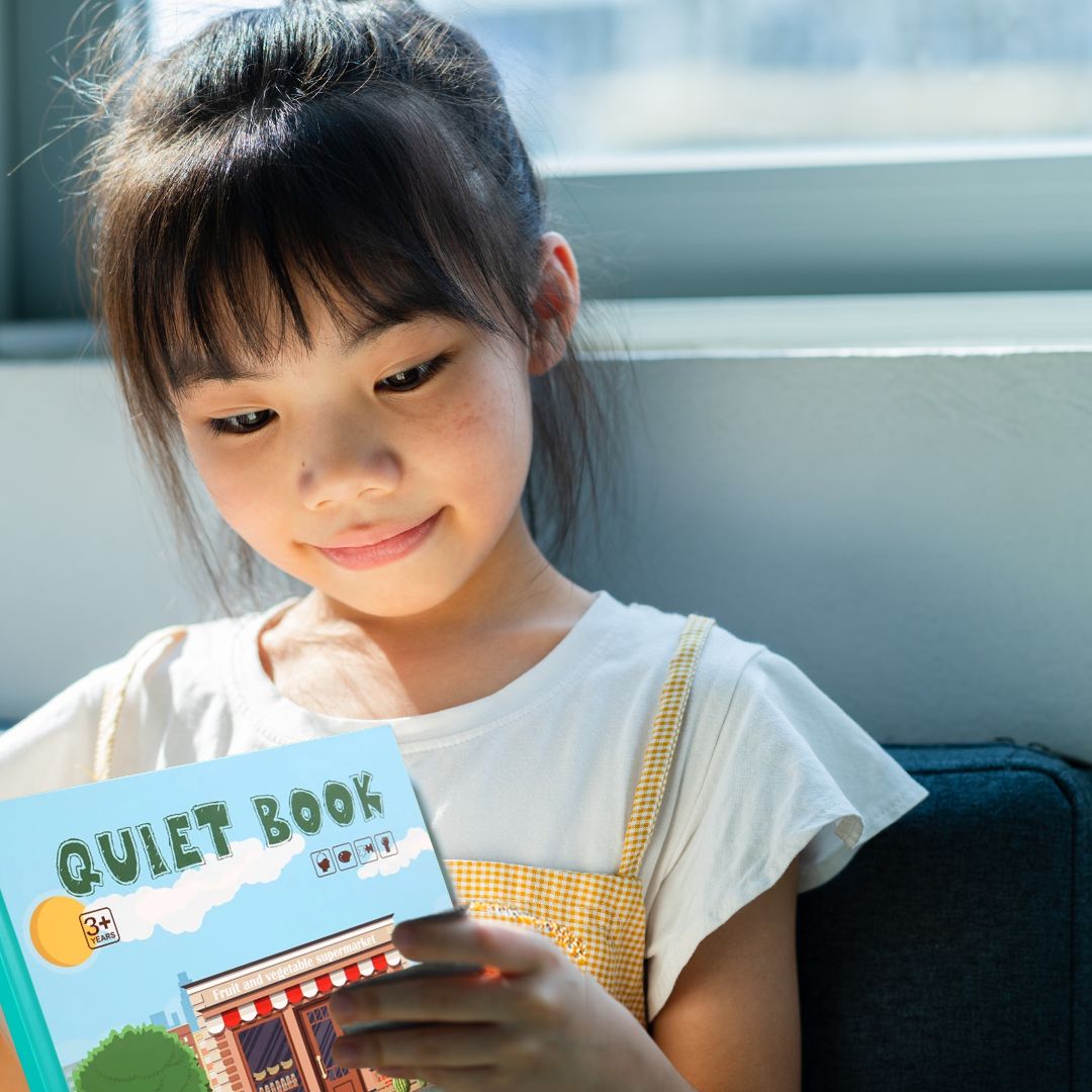 une fille de 6 ans concentrée dans ses livres pour enfant de la collection Busy Book