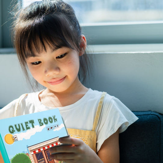 une fille de 6 ans concentrée dans ses livres pour enfant de la collection Busy Book