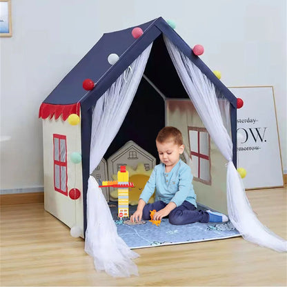 un garçon joue dans sa maisonnette enfant bleu-blanc-rouge avec ses blocs de construction c est son royaume de création