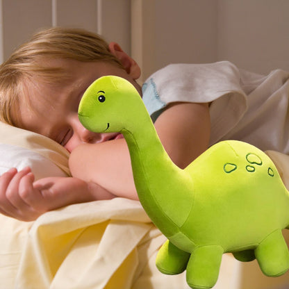 un garçon dort paisiblement avecsa peluche dinosaure verte au long coup 