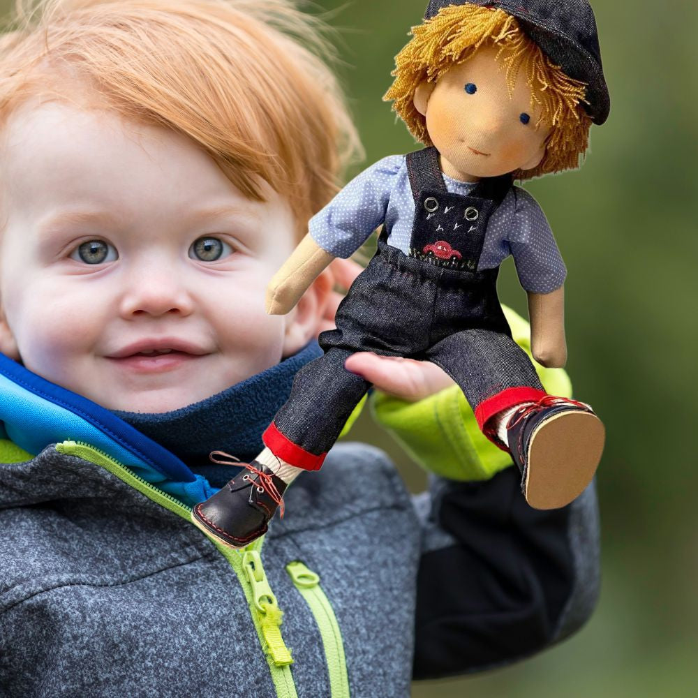 un gamin joue avec sa poupée de chiffon garçon comme lui