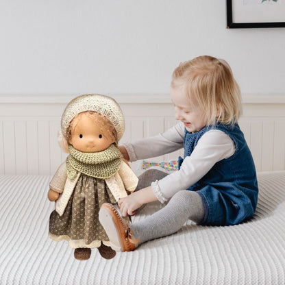 une fillette habille sa poupee de chiffon blonde waldorf 