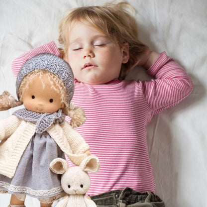 jolie petite fille dort profondément grace a sa poupee de chiffon blonde rassurante