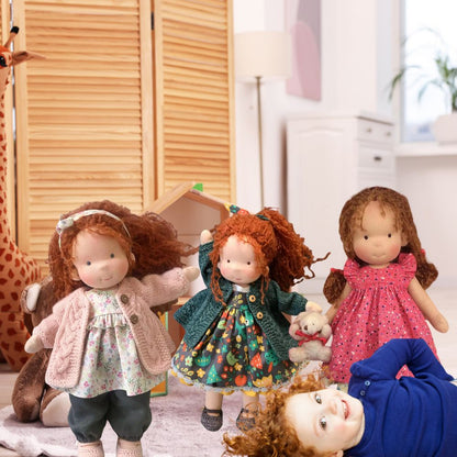 une petite fille rousse joue avec ses poupée en chiffon rousses