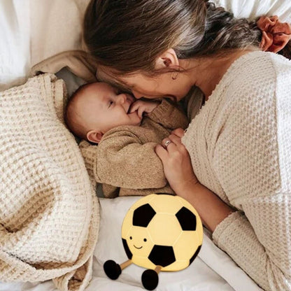 une mère caline son bébé à la lueur de la veilleuse bébé en forme de ballon foot Monsieur Foot